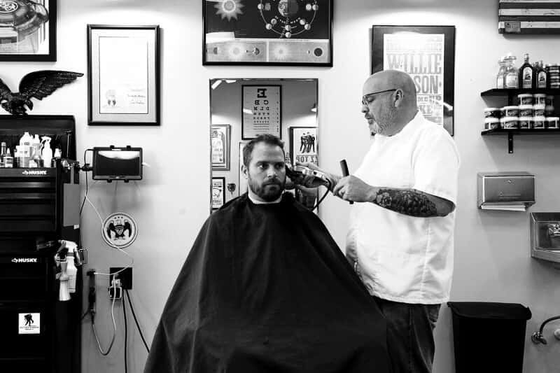 A barber giving a client a clipper cut at Monty's Barber Shop