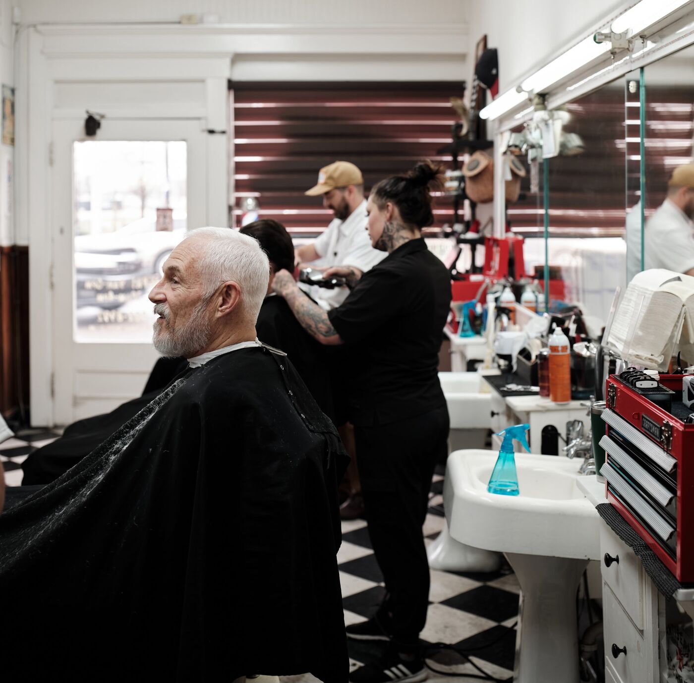 A wide view of the barbers at work inside Monty's Barber Shop on Charlotte Ave