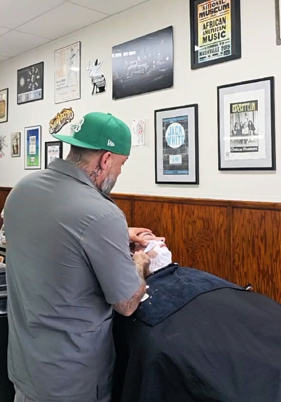 A barber giving a client a straight-razor shave at Monty's Barber Shop